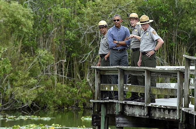 President Barack Obama walks the Anahinga Trail at Everglades National Park, Florida, on Wednesday. Obama visited the Everglades on Earth Day to talk about how global warming threatens the U.S. economy. He says rising sea levels are putting the "economic engine for the South Florida tourism industry" at risk. 