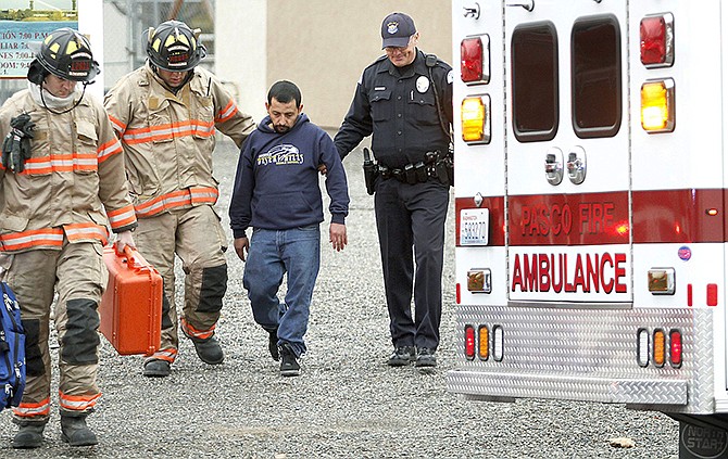 Pasco firefighters and Dean Perry, right, a Pasco police officer, help Antonio Zambrano-Montes, second from right, to an ambulance in January following a house fire in Pasco, Washington. On Feb. 10, Zambrano-Montes was fatally shot by police after he ran from them after throwing rocks at cars at an intersection.