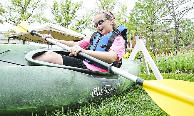 Brooklynn Fischer, a fourth-grade student from Montgomery City Elementary School, tries to keep her balance while paddling the kayak hanging just inches off the ground. Elementary school students from across the Mid-Missouri area converged on the Capitol Friday for Earth Day activities.