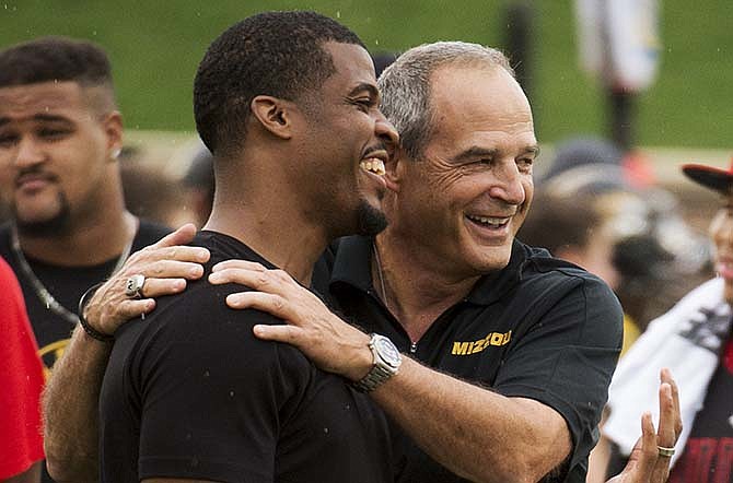 Missouri head coach Gary Pinkel, right, laughs with his former quarterback Brad Smith, left, as they stand on the sideline during an NCAA college spring football game Saturday, April 18, 2015, in Columbia, Mo. The university has extended Pinkel's contract through the 2019 season and upped his yearly salary to $4.02 million