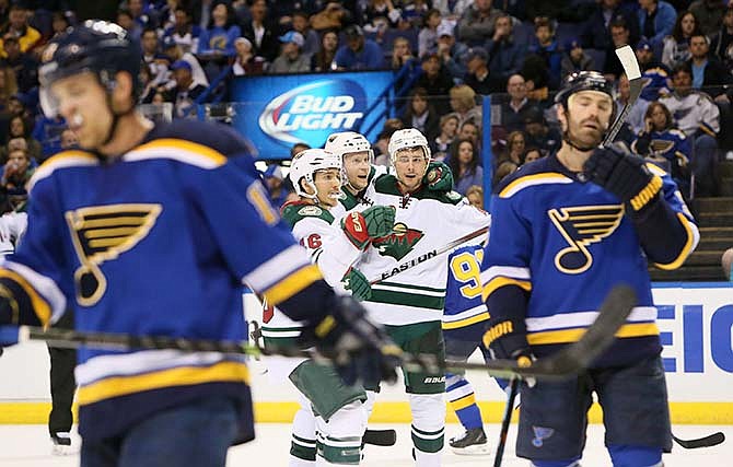Minnesota Wild's Jared Spurgeon, center left, center Mikko Koivu and Nino Niederreiter, center right, celebrate Niederreiter's second-period goal in Game 5 of an NHL hockey first-round playoff series against the St. Louis Blues on Friday, April 24, 2015, in St. Louis. (Chris Lee/St. Louis Post-Dispatch via AP)