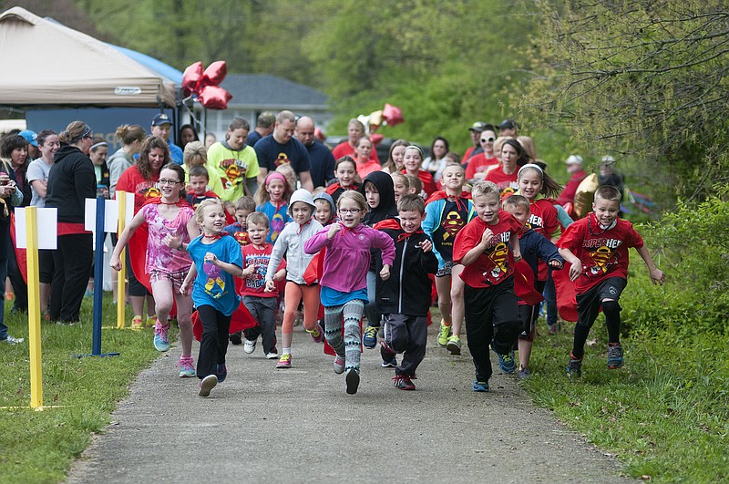 Children take off from the starting line during the Super Sam Foundation's Superhero Kids' Mile on Saturday at McIntire Elementary School. 