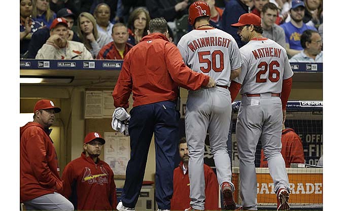 St. Louis Cardinals starting pitcher Adam Wainwright (50) is helped off the field after getting injured while batting during the fourth inning of a baseball game against the Milwaukee Brewers Saturday, April 25, 2015, in Milwaukee.
