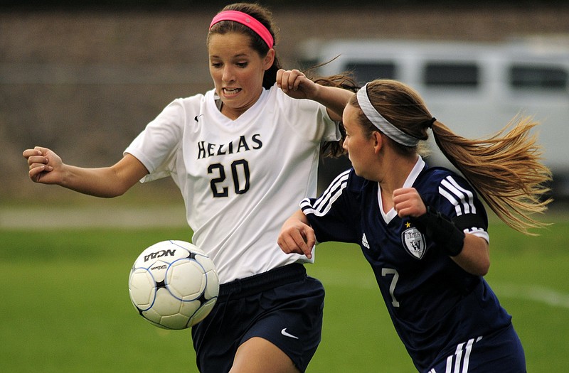 Helias' Janie McCurren battle for possession with Lee's Summit West's Mackenzie Hill.