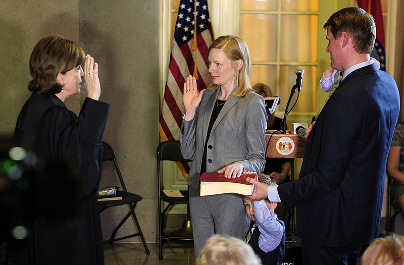 Supreme Court of Missouri Chief Justice Mary R. Russell, left, administers the oath of office to Nicole Galloway, center, as she assumes the duties of State Auditor during a swearing in ceremony at the Missouri Capitol on Monday.