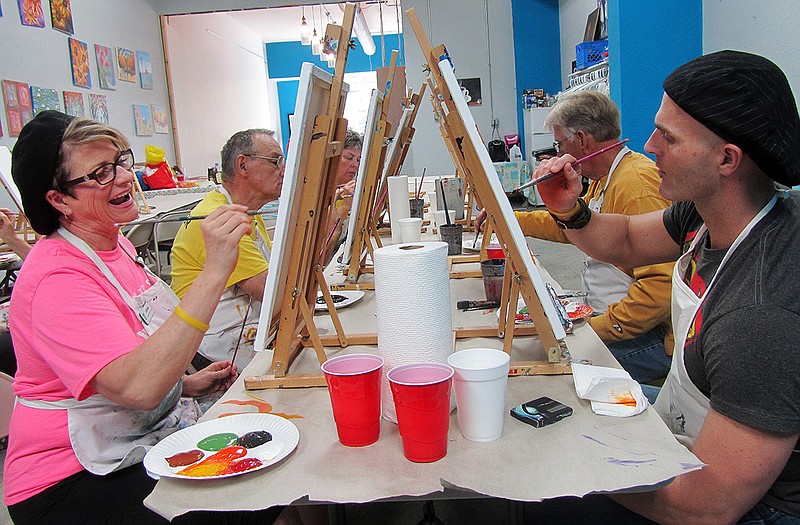 YMCA instructors Donna Prenger and Nick Baker are both wearing their fanciest artist hats while painting with the group of YMCA LiveSTRONG survivors.