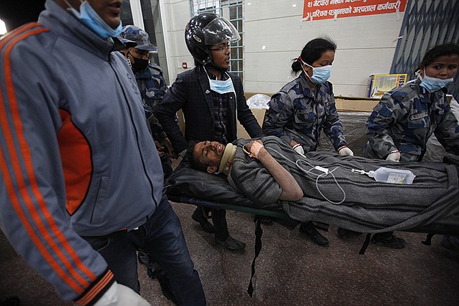 Survivor Rishi Khanal, 27, is carried on a stretcher after being freed by French rescuers from the ruins of a three-story hotel in the Gangabu area of Kathmandu, Nepal, on Tuesday. Across central Nepal, including in Kathmandu, the capital, hundreds of thousands of people are still living in the open without clean water or sanitation since Saturday's massive earthquake, one of the worst to hit the South Asian nation in more than 80 years. 