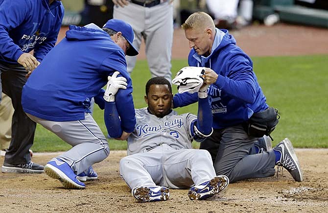 Kansas City Royals' Alcides Escobar is helped up by trainers after getting hit by a pitch from Cleveland Indians starting pitcher Danny Salazar in the fifth inning of a baseball game, Wednesday, April 29, 2015, in Cleveland. Escobar left the game.