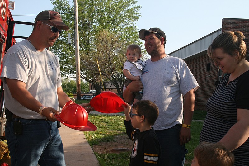 Mark Cram giving fire hats to the children in attendance.