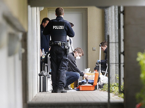 German police officers secure evidence in front of an apartment in Oberursel, Germany, Thursday. Chief of police for western Hesse state Stefan Mueller said authorities found a pipe bomb, 100 rounds of ammunition, parts of an assault rifle and a chemical that can be used to build a bomb during a raid overnight in the town of Oberursel.