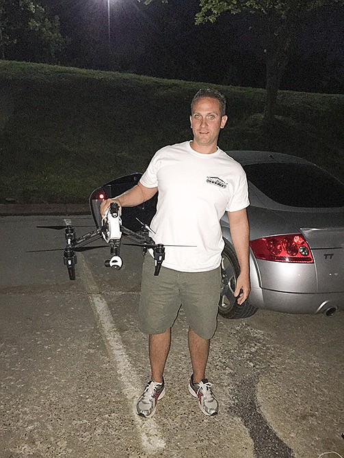 Jeremiah Nelson poses with the drone that he and partner Gene Fairfax use with their business, Homeland Roofing & Restoration LLC.