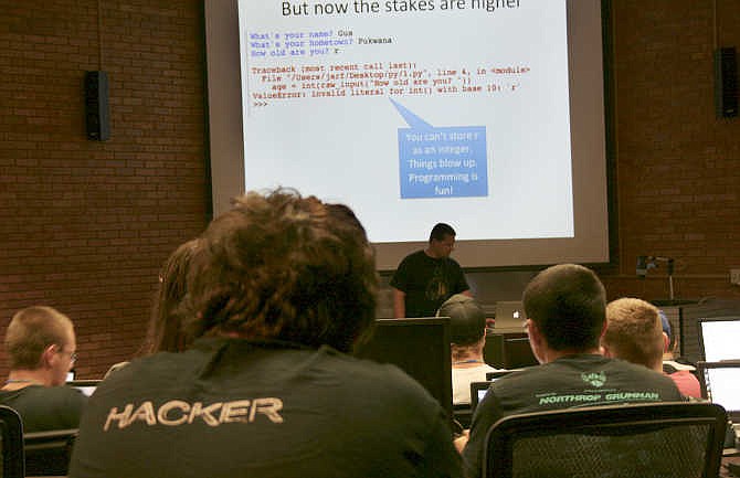 In this July 23, 2014 photo released by Dakota State University, Josh Pauli teaches programming to high school students at the GenCyber Camp on the school's campus in Madison, S.D., It was one of six camps held nationally in 2014 that were funded by the National Science Foundation and National Security Agency. With the increased demand, the NSA and NSF are collaborating to host 43 GenCyber summer camps in around the country in the 2015. (Erica Clements/Dakota State University via AP)
