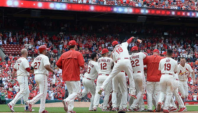 St. Louis Cardinals celebrate after a walkoff sacrifice fly by Matt Carpenter to defeat the Pittsburgh Pirates 2-1 in the eleventh inning of a baseball game, Saturday, May 2, 2015, at Busch Stadium in St. Louis. 