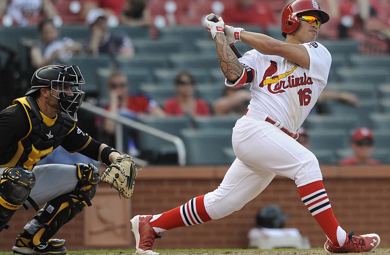 Kolten Wong of the Cardinals follows through on his walk-off home run in front of Pirates catcher Chris Stewart in the 14th inning of Sunday's game at Busch Stadium.