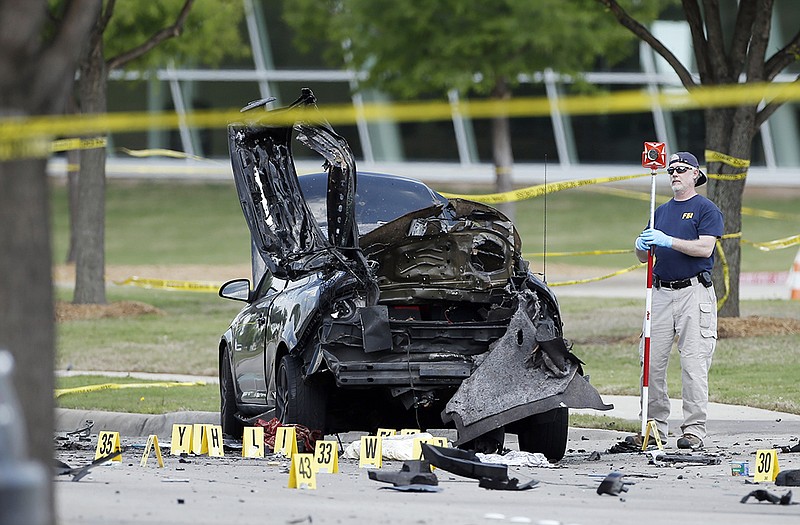 An FBI crime scene investigator documents evidence in Garland, Texas, after two men opened fire with assault weapons on guards at a contest for Muslim Prophet Muhammed cartoons. 