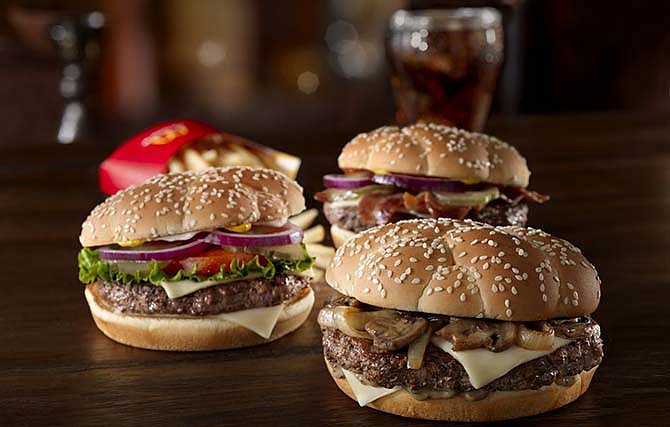 This undated product image provided by McDonald's shows the fast food chain's new trio of "Sirloin Third Pound" burgers: the Steakhouse, foreground right, Lettuce & Tomato, left, and Bacon & Cheese.