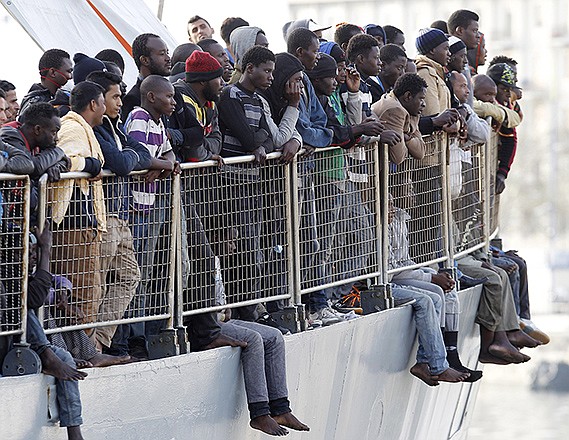Migrants wait to disembark from the Iceland Coast Guard vessel Tyr at the Messina harbor, Sicily, southern Italy, Wednesday. This weekend saw a dramatic increase in rescues as smugglers in Libya took advantage of calm seas and warm weather to send thousands of would-be refugees out into the Mediterranean in overloaded rubber boats and fishing vessels.