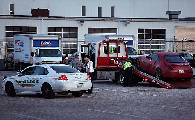 In this May 5, 2015, photo, a 2007 Nissan 350ZX is loaded on to the back of tow tuck after it was found in the St. Louis suburb of Hazelwood, Mo. The body of Taylor Clark, an Illinois college student who went missing while trying to sell his sports car on Craigslist, was found Tuesday night near a driving school not far from where his abandoned vehicle, the 2007 Nissan 350ZX, was found according to authorities. (David Carson/St. Louis Post-Dispatch via AP)