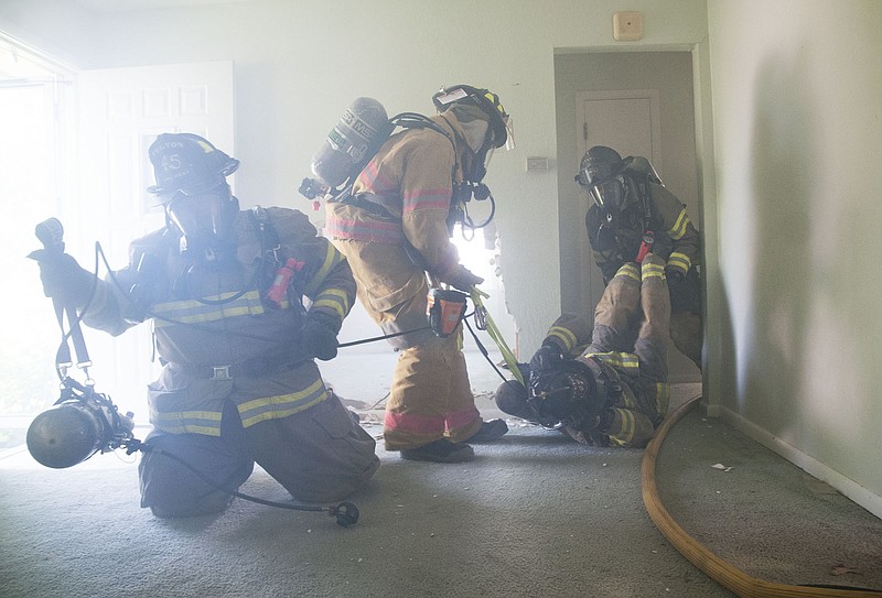 Fulton firefighters move firefighter James Noah out of a room during a training exercise at a home on St. Francis Street on Tuesday. Firefighters practiced a "firefighter mayday" drill, which simulated Noah as an injured firefighter in need of being removed from a burning home. Fulton Public Schools donated the home to the fire department for training.
