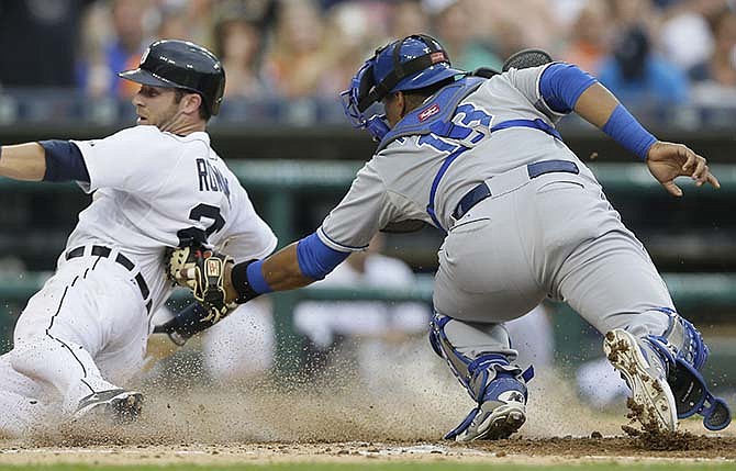 Detroit Tigers' Andrew Romine, left, beats the tag of Kansas City Royals catcher Salvador Perez during the second inning of a baseball game, Friday, May 8, 2015, in Detroit. 