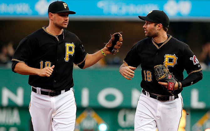 Pittsburgh Pirates second baseman Neil Walker (18) and shortstop Jordy Mercer celebrate after getting the third out of a triple play in the second inning of a baseball game in Pittsburgh, Saturday, May 9, 2015. Cardinals' Yadier Molina hit a line drive to Walker that he caught for the first out, then Walker threw to third to get the second out on Cardinals' Jhonny Peralta, then Pirates third baseman Jung Ho Kang threw back to Walker at third to complete the triple play.