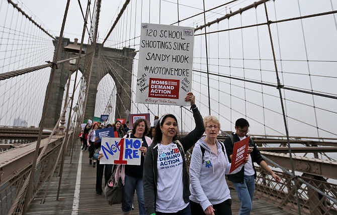 Demonstrators march over the Brooklyn bridge during the third annual Brooklyn bridge march and rally to end gun violence Saturday, May 9, 2015, in New York. Organizers said the proliferation of guns results in an average of more than 80 deaths a day across the country.