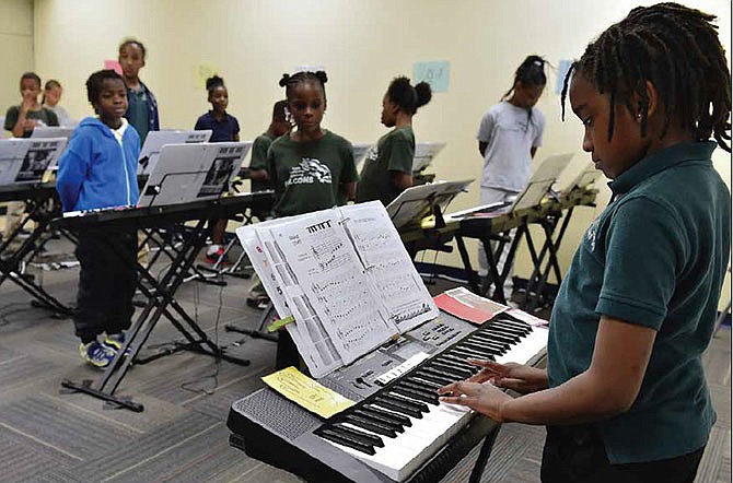Third-graders listen politely as their classmate Camille Moore performs April 20, 2015, in Kansas City at Hope Leadership Academy, a small Missouri charter school that had received a classroom full of keyboards from the New York City non-profit Music and the Brain.