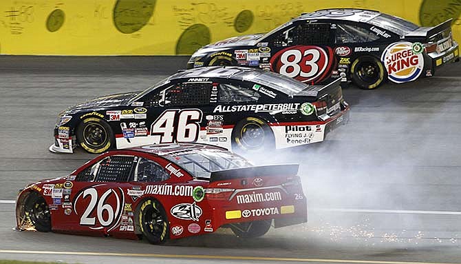 NASCAR driver Jeb Burton (26) saves control below Matt DiBenedetto (83) and Michael Annett (46) during a Sprint Cup Series auto race at Kansas Speedway in Kansas City, Kan., Saturday, May 9, 2015.