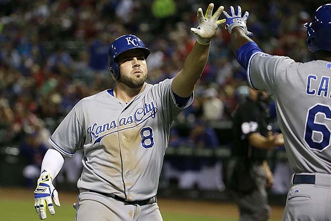 Kansas City Royals Mike Moustakas (8) gets a congrats from teammate Lorenzo Cain (6) after Moustakas hit a solo home run during the seventh inning of a baseball game against the Texas Rangers in Arlington, Texas, Tuesday, May 12, 2015.
