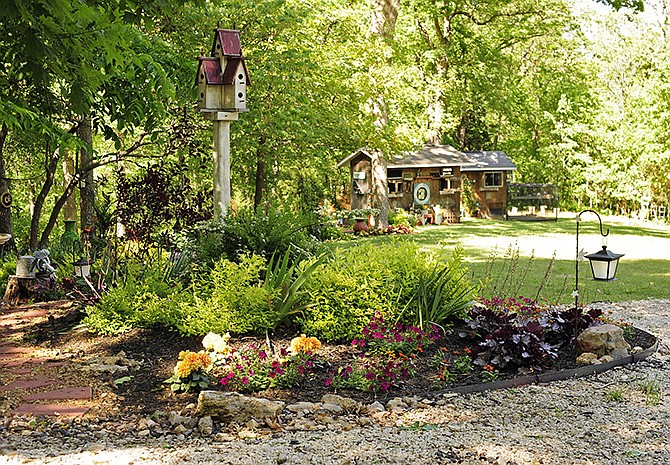 Decorated with antique accessories and seven different flower beds of varying sizes, colors and textures, Mary Callahan was awarded the Master Gardener and Bittersweet Garden Club's Yard of the Month award for her wooded wonderland at 362 Cannondale Road. Pictured here is Callahan's backyard, which features a pigeon coop and multiple walking paths that lead from the garden into the woods surrounding her home. 