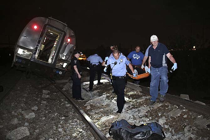 Emergency personnel work the scene of a deadly train wreck, Tuesday, May 12, 2015, in Philadelphia. An Amtrak train headed to New York City derailed and tipped over in Philadelphia.
