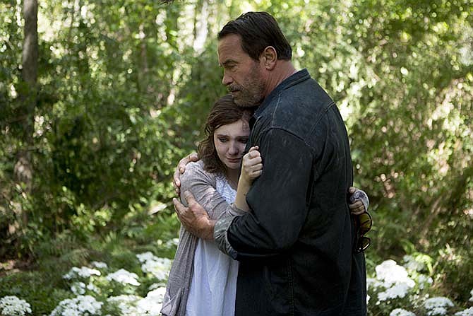 In this image released by Roadside Attractions, Abigail Breslin, left, and Arnold Schwarzenegger appear in a scene from "Maggie."