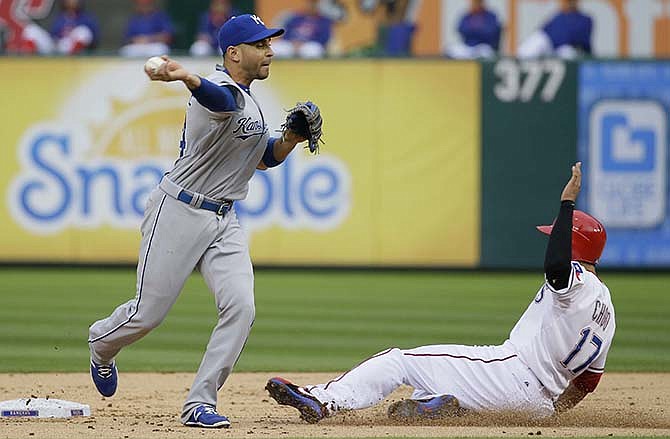 Kansas City Royals second baseman Omar Infante, left, throws to first after forcing out Texas Rangers' Shin-Soo Choo (17) during the second inning of a baseball game in Arlington, Texas, Wednesday, May 13, 2015. Delino DeShields was out at first on the double play.