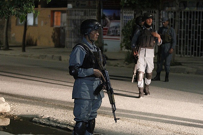 Afghan security forces inspect the site of a Park Palace Hotel attack by Taliban militants, in Kabul, Afghanistan, on Wednesday. Gunmen have stormed a guesthouse in the Afghan capital used by both foreigners and locals, sparking a gun battle with police.
