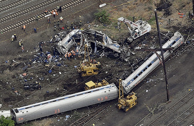 Emergency personnel work at the scene of a deadly train derailment on Wednesday in Philadelphia. The Amtrak train, headed to New York City, derailed and crashed in Philadelphia on Tuesday night, killing at least seven people and injuring dozens of others.