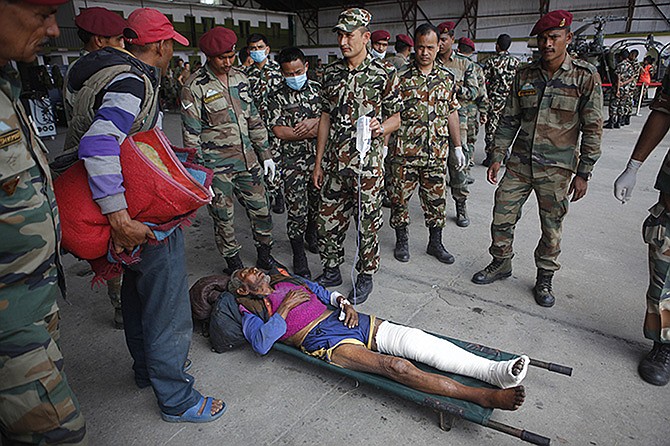 A Nepalese person injured in Tuesday's earthquake brought from Charikot, Dolakha District, lies on a stretcher at the Tribhuvan International Airport in Kathmandu, Nepal, on Wednesday.