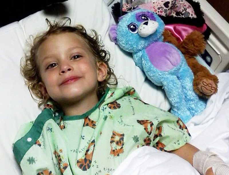 Faith Rowell, 4, of Holts Summit, smiles in a hospital bed Thursday at University of Missouri Hospital in Columbia. Rowell suffered injuries to her right leg and left hand during a riding lawn mower accident on Tuesday. Her father, Todd Rowell, said this picture shows her smiling for the first time following the accident when he told Faith Rowell that he watered her tomatoes.