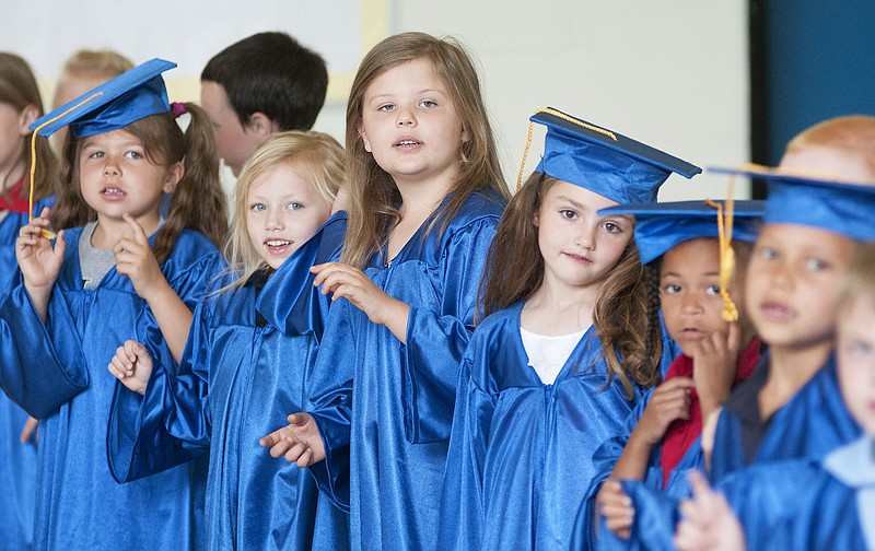 Olivia McElroy (center), a Kingdom Christian Academy kindergarten graduate, and her classmates sing during kindergarten graduation on Thursday.