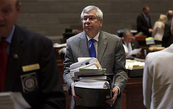 State Sen. Wayne Wallingford, R-Cape Girardeau, carries stacks of papers from his desk off the Senate floor after the body adjured early, Friday, May 15, 2015, in Jefferson City, Mo. Conceding that nothing more could be accomplished, Senate Majority Leader Ron Richard moved that the Senate adjourn nearly three hours ahead of the 6 p.m. deadline and after days of Senate Democrats stalling work to demonstrate their frustration over Republican passage of a bill limiting union powers earlier this week.