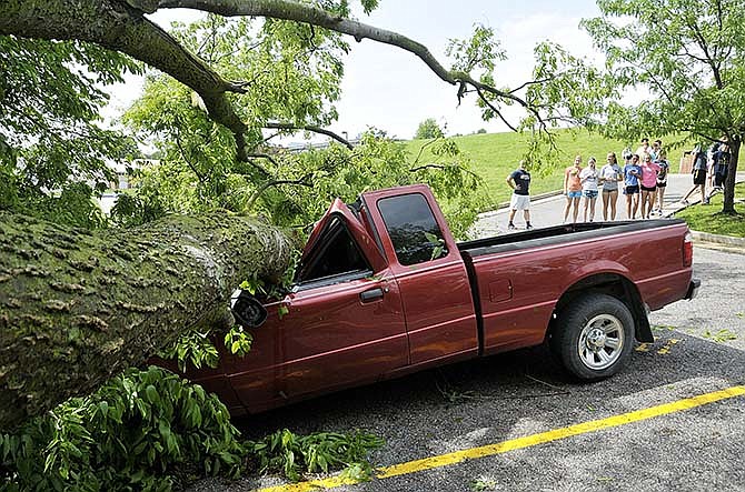 
Before the start of track practice, several students
visited the parking lot to see two vehicles damaged
after a tree fell across the fence into the
lower Carter Street parking lot just to the east of
Helias High School.