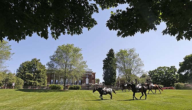 In this photo taken on Wednesday, May 13, 2015, graduating seniors at Sweet Briar college participate in the traditional senior ride on the quad at the school in Sweet Briar, Va. The senior ride is a tradition where seniors are allowed to ride horses on school grounds. The school, which is slated to close in August, held its final commencement ceremonies on Saturday, May 16. 