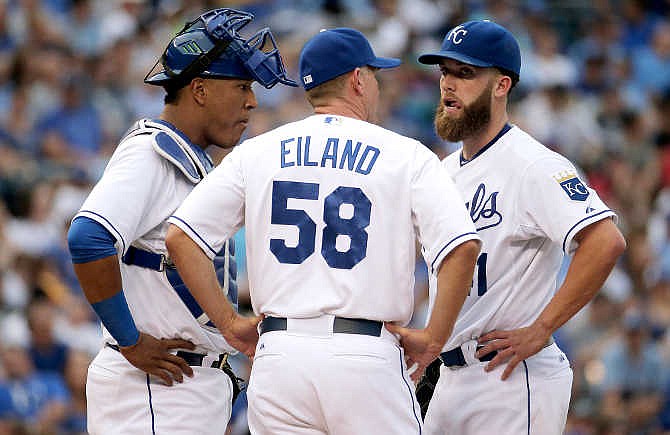 Kansas City Royals starting pitcher Danny Duffy, right, talks to catcher Salvador Perez and pitching coach Dave Eiland (58) after walking a batter during the third inning of a baseball game against the New York Yankees on Saturday, May 16, 2015, in Kansas City, Mo. 