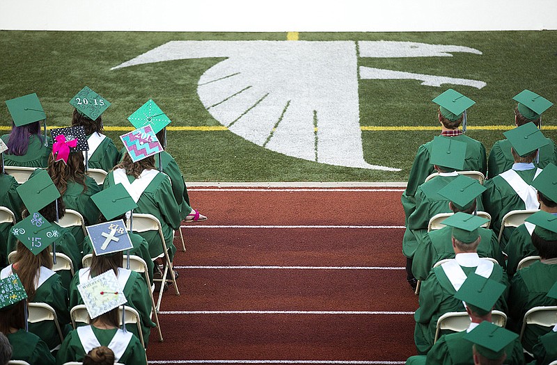 Members of the Blair Oaks High School class of 2015 sit in their seats Sunday during the graduation ceremony. Female graduates, on the left, appeared to be much more likely to add a personal decoration to their mortarboards. 