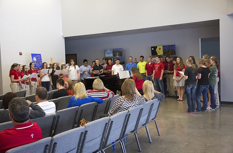 A choir made up of alumni and current students performs an arrangement of Amazing Grace Sunday at Calvary Lutheran High School during the school's 10th anniversary celebration.