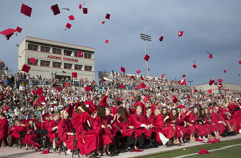 Members of the Jefferson City High School class of 2015 throws their caps in the air after receiving their diplomas and officially graduating high school Sunday evening at Adkins Stadium. 