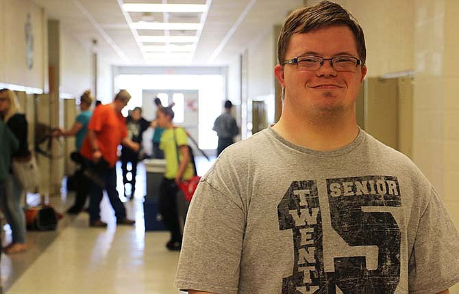 Chris Kampeter poses for a photo in the hallway at New Bloomfield High School on his last
day Wednesday. Chris, a student with Down syndrome, graduated Friday. Chris bounced
around from school to school for several years, his family attempting to find the right fit.