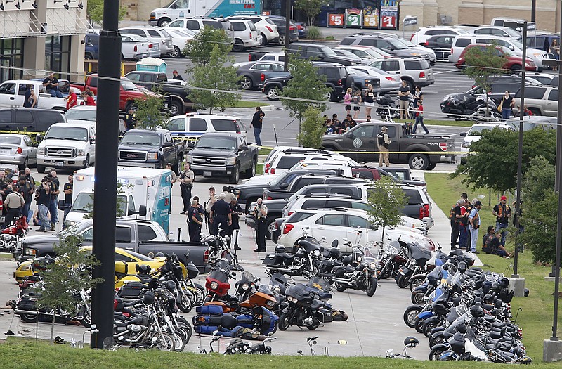 Law enforcement officers investigate a shooting in the parking lot of the Twin Peaks Restaurant Sunday in Waco, Texas. Waco police Sgt. W. Patrick Swanton told KWTX-TV there were multiple victims after gunfire erupted between rival biker gangs at the restaurant. 