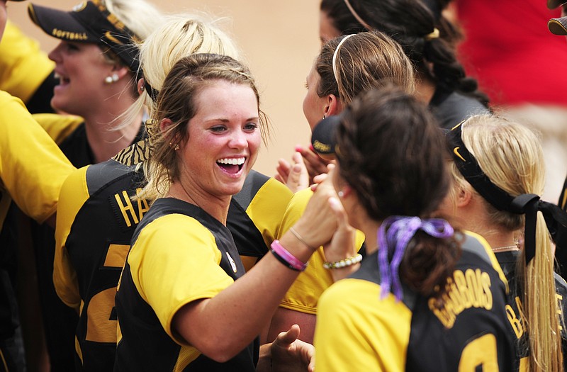 Natalie Fleming (center) celebrates Sunday with Tiger teammate Taylor Gadbois after Missouri defeated Kansas 7-6 to win the regional softball title at University Field in Columbia.