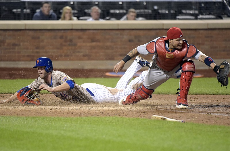 Eric Campbell of the Mets scores the game-winner as Cardinals catcher Yadier Molina fields the throw in the bottom of the 14th inning of Monday night's game in New York.