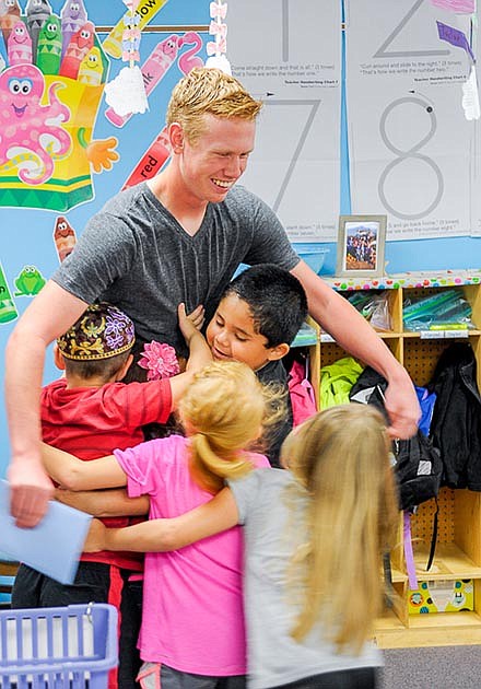 Kindergartners in Amy Mouse's classroom surround 2015 graduate Alex Dalbey as he leaves for the last time after tutoring each morning during the last school year to qualify for the A+ program.